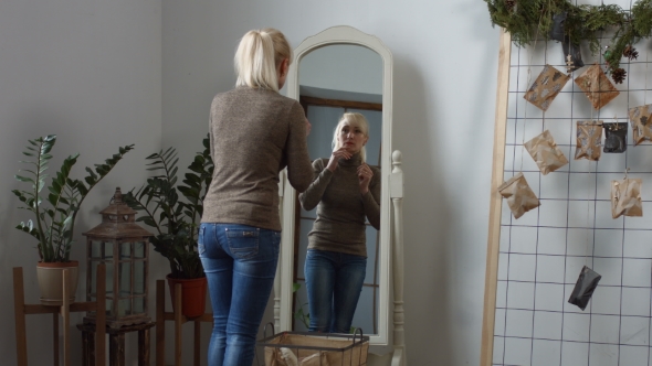 Sad Woman Looking in the Mirror at Her Wrinkles alt