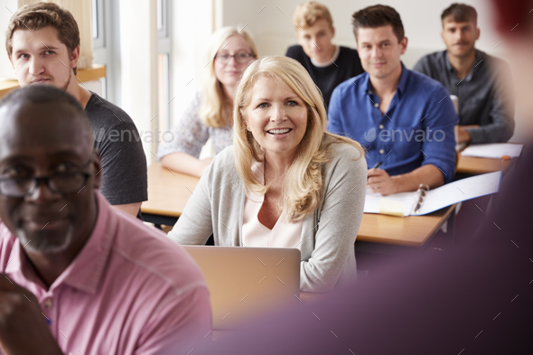 Male Tutor Teaching Class Of Mature Students Viewed From Behind Stock Photo by monkeybusiness