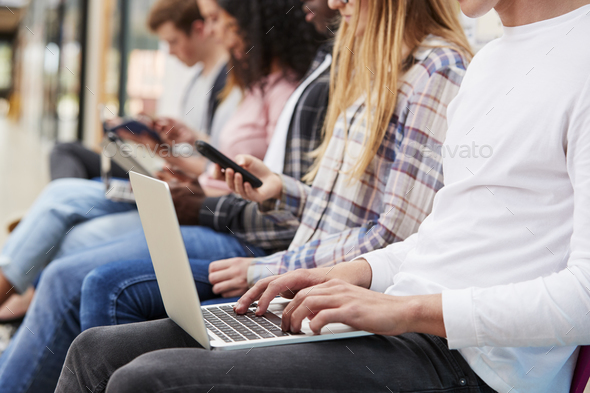 Close Up Of Seated College Students Using Digital Technology Stock Photo by monkeybusiness