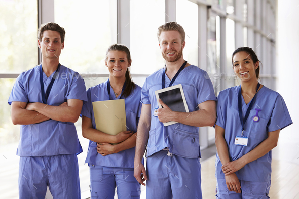 Group portrait of healthcare workers in hospital corridor Stock Photo by monkeybusiness