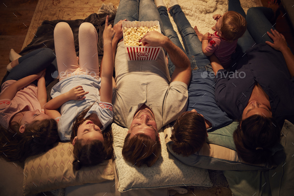 Overhead View Of Family Enjoying Movie Night At Home Together Stock Photo by monkeybusiness