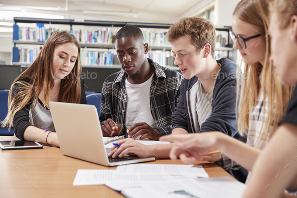 Group Of College Students Collaborating On Project In Library Stock Photo by monkeybusiness