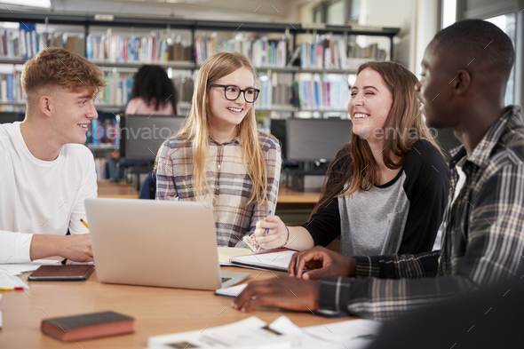 Group Of College Students Collaborating On Project In Library Stock Photo by monkeybusiness
