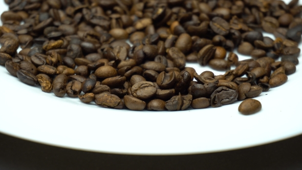 Camera Slides Above Coffee Beans on the White Plate. alt