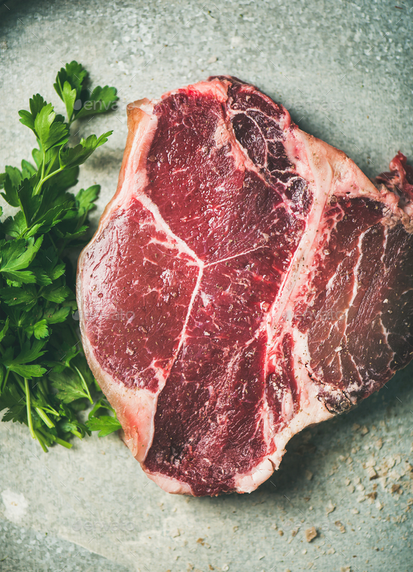 Flat-lay of raw uncooked dry-aged t-bone prime beef steak - Stock Photo - Images