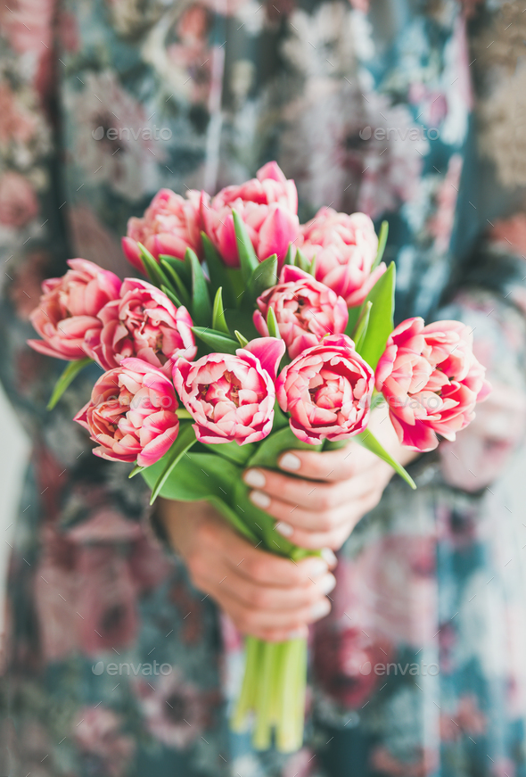 Woman in colorful dress holding bouquet of pink tulips - Stock Photo - Images