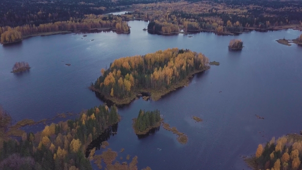 Woody Island on a Blue Lake in the Middle of Autumn Forest. Aerial Shot alt