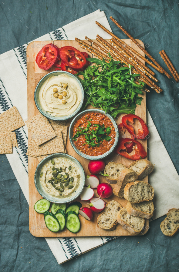 Vegetarian dips hummus, babaganush, muhammara on wooden board - Stock Photo - Images