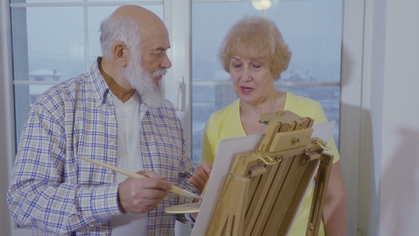 Senior Man with Senior Woman Are Drawing Picture on Easel alt