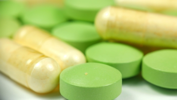 White Green Pills Rotate on a White Background