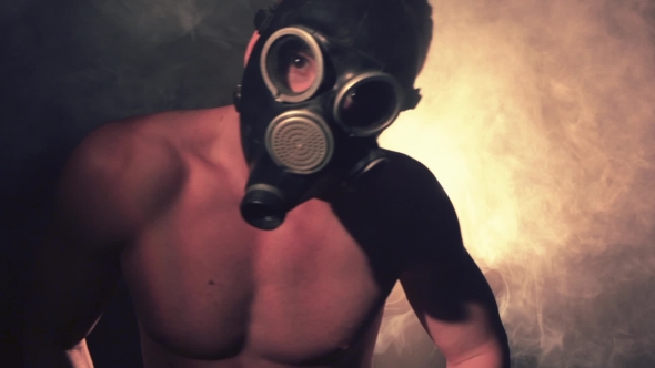 Man Wearing a Gasmask Dances in Smoke