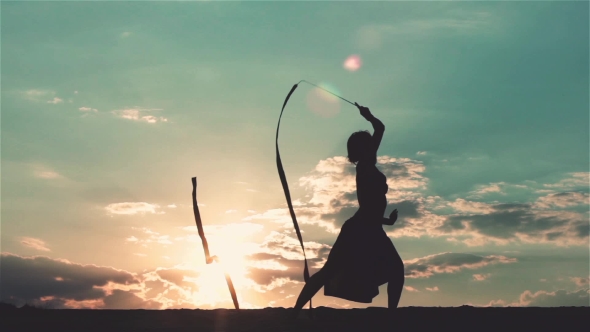 Silhouette of Dancing Woman at Sunset