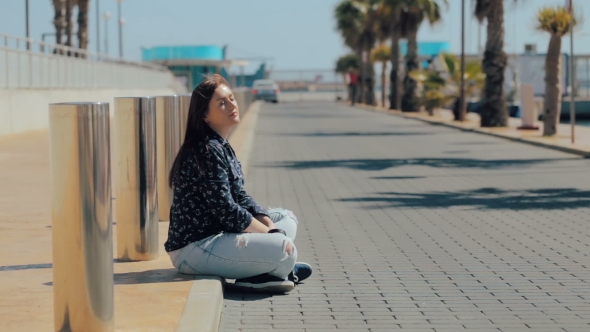 Young Woman Relaxing Sitting on the Road Near Sea