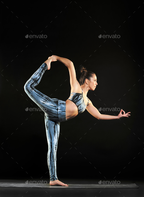 Woman doing a dancer pose during a yoga workout - Stock Photo - Images