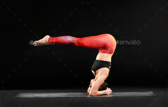 Muscular woman doing a headstand with pike legs - Stock Photo - Images