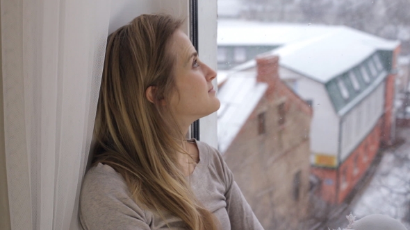 Beautiful Woman Dreaming and Sitting on Windowsill