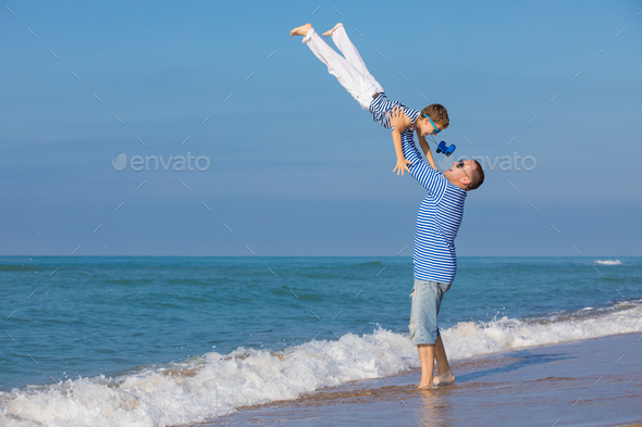Father and son playing on the beach at the day time. Concept of - Stock Photo - Images