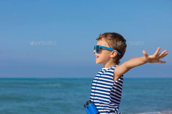 One happy little boy playing on the beach at the day time - Stock Photo - Images