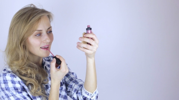Beautiful Woman Paints Her Lips Looking on Little Mirror