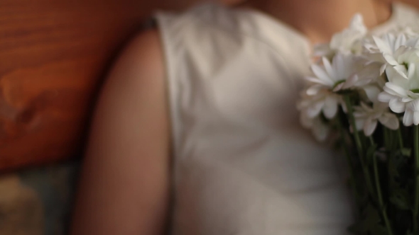 Girl with a Bouquet of Flowers of Chamomiles