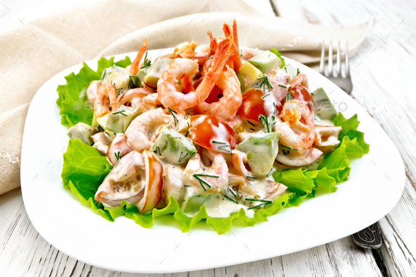 Salad with shrimp and tomato in plate on light board - Stock Photo - Images