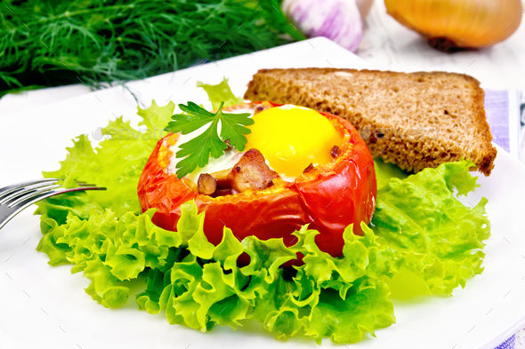 Scrambled eggs in tomato and bread on light board - Stock Photo - Images