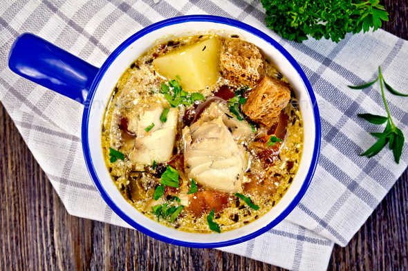 Soup fish with vegetables and croutons on board top - Stock Photo - Images