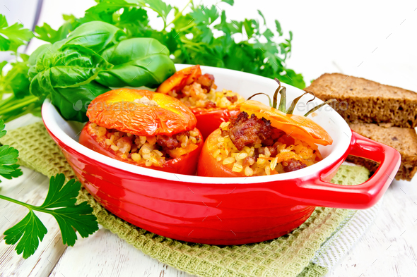 Tomatoes stuffed with bulgur in pan on light board - Stock Photo - Images