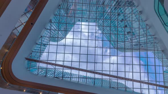 Time lapse of Looking up through the sun roof at office building at clouds and sunshine. alt