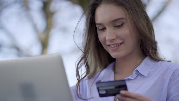 Smiling Woman Typing on Laptop, Paying Online with Credit Card alt