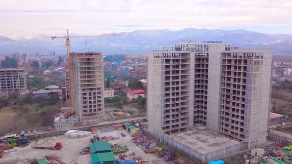 Drone view of construction of multi-storey buildings background of mountains. alt