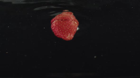 Fresh Strawberries Splashing Falling in Water on Slow Motion with Reflections alt