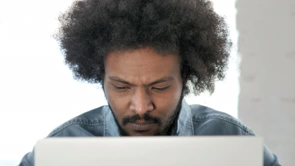 Close Up of Frustrated Creative African Man Reacting To Loss alt