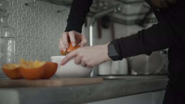 Woman Preparing Orange Juice On Kitchen alt