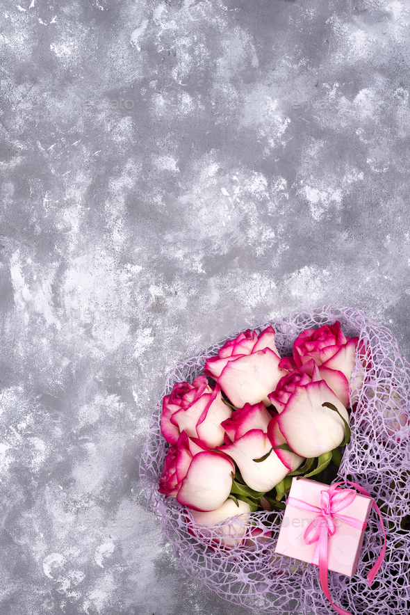 Red white rose flower bouquet with pink gift box on stone table. - Stock Photo - Images