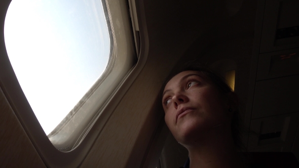 Sad Woman at Porthole in Plane