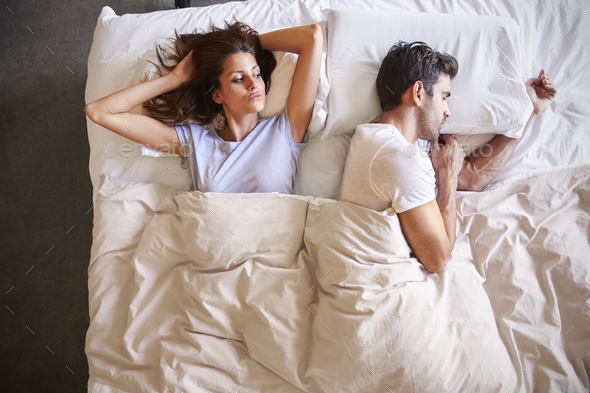 Overhead View Of Couple With Relationship Problems Lying In Bed Stock Photo by monkeybusiness