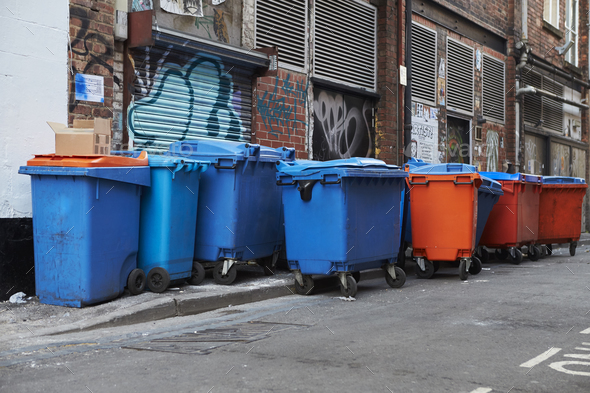 Manchester, UK - 10 May 2017: Group Of Wheelie Bins In Manchester Street Stock Photo by monkeybusiness