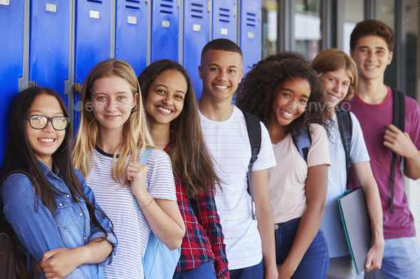 Teenage school kids smiling to camera in school corridor - Stock Photo - Images