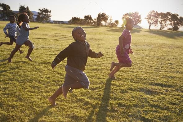 Elementary school boys and girls running in an open field Stock Photo ...