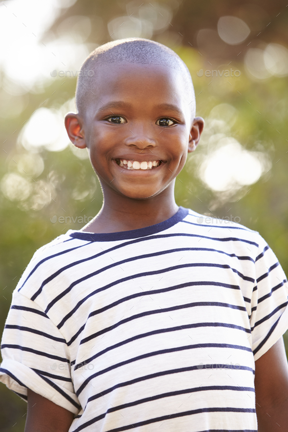 Smiling young black boy looking away from camera outdoors Stock Photo ...