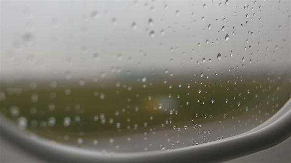 View From the Plane on the Apron Through the Window with Rain Drops