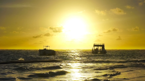Sunrise over Ocean Waves with Two Boats