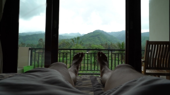 Young Happy Man Relaxing on Country House Veranda, Point of View Feet Lay on Bed, Wonderful Green