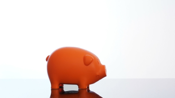 Businessman Hand Putting a Bitcoin in a Piggy Bank