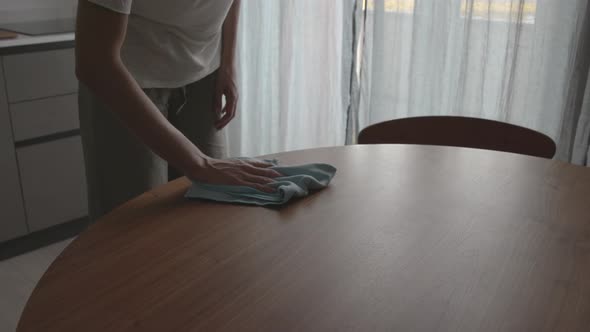 Woman cleaning the kitchen table with a cloth