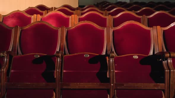 Theater Seats Row Lit By Spotlight Red Velvet Chairs in Empty Theatre Hall alt