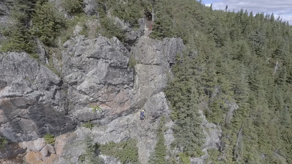 A Drone Flies Over a Rock Climber