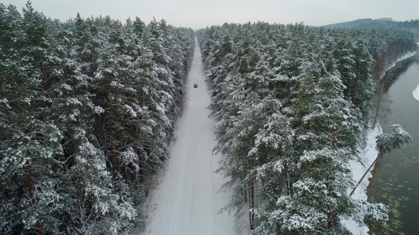 Aerial View of Car Moving in Winter Forest