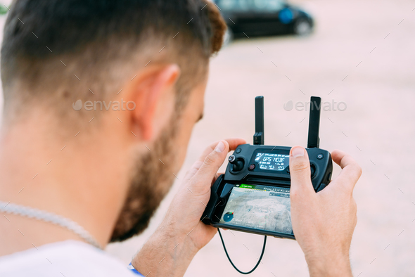 Guy controls drone with remote control - Stock Photo - Images